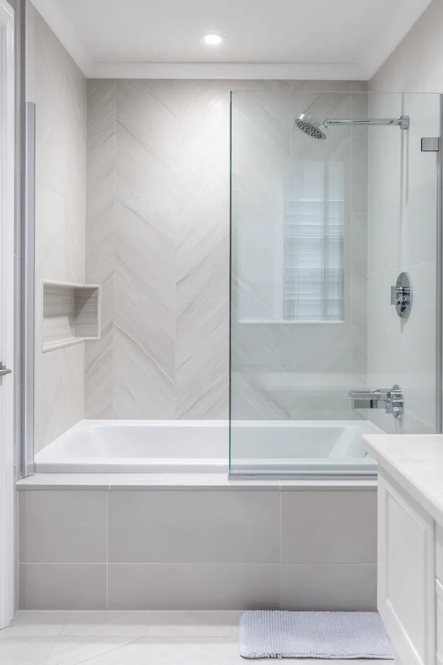 small bathroom featuring a modern tub-shower combo. Glass enclosure, sleek white tub, and rainfall showerhead. 